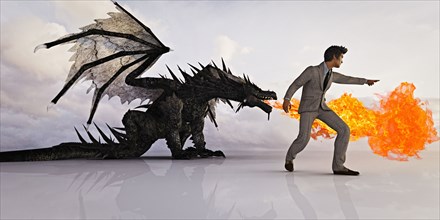 Businessman directing fire breathing dragon