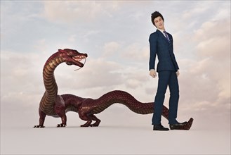 Businessman standing on tail of dragon