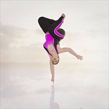Woman balancing upside-down on fingertip