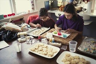 Mixed race brother and sister decorating cookies
