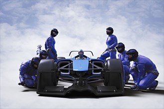 Futuristic pit crew servicing race car