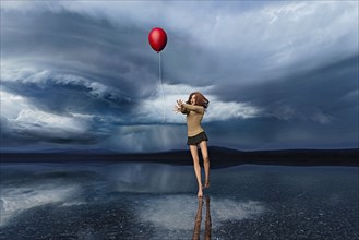 Girl chasing red balloon