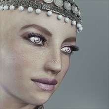 Face of futuristic woman wearing ornate headpiece