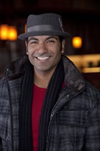 Smiling man wearing scarf and fedora