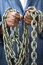 Caucasian worker holding chains