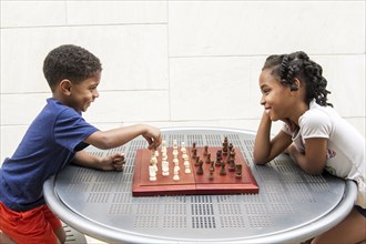African American brother and sister playing chess