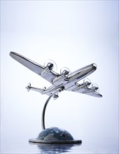 Model of airplane flying over globe