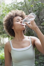 Mixed race woman drinking water