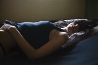 Sleeping mixed race woman laying in bed