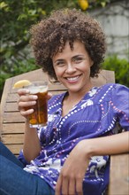 Mixed race woman drinking iced tea