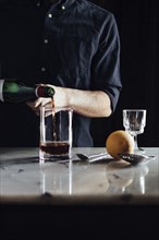 Caucasian bartender pouring cocktail in glass