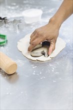 Baker using cookie cutter in dough