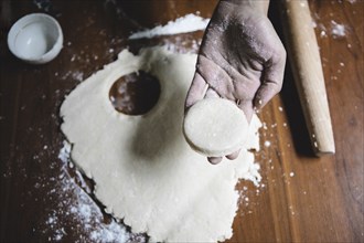 Mixed race baker cutting circle of dough