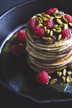 Pistachios and raspberries on pancakes