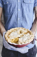 Caucasian man holding peach pie