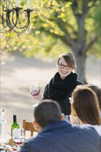 Woman toasting with wine at outdoor table