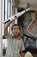 Mixed race boy playing with model rocket