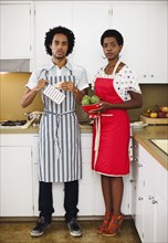 African American woman and husband cooking in kitchen