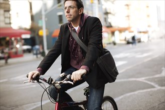 Caucasian man riding bicycle on urban street