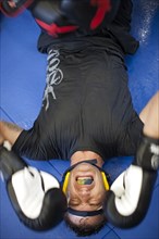 Caucasian boxer grimacing on mat