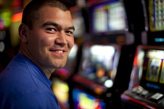 Native American man playing slot machine in casino