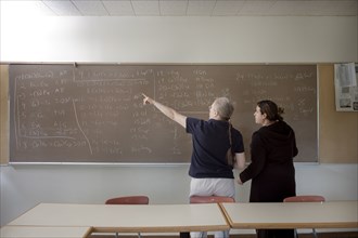 Teacher explaining arithmetic to student in classroom