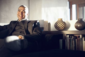Smiling mixed race businessman sitting in chair