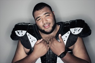 Mixed race man in football shoulder pads