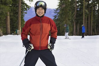 Chinese man wearing ski gear in snow