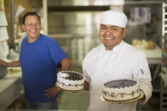 Hispanic baker smiling in kitchen