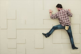 Caucasian climber scaling geometric wall