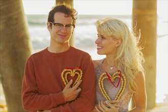 Caucasian couple holding woven hearts