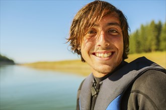 Caucasian man smiling by rural lake