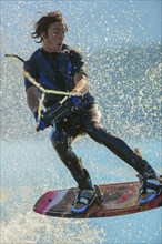 Caucasian man wakeboarding on lake