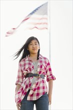 Chinese girl smiling in front of American flag