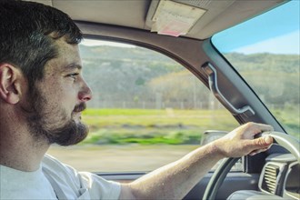Caucasian man driving car on rural road