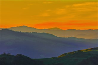 Silhouette of remote hills under sunset sky