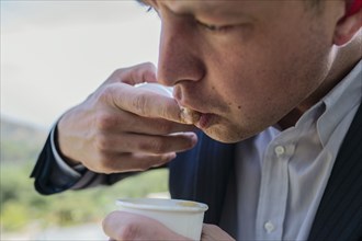 Close up of Caucasian businessman tasting coffee