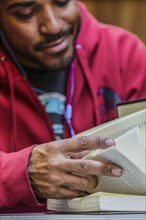 Close up of mixed race man reading book