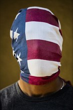 American flag covering face of mixed race man