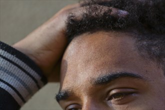 Close up of hand in hair of mixed race man