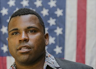 Close up of Black man in front of American flag