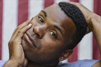 Close up of concerned Black man  in front of American flag