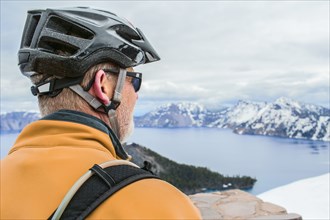 Caucasian cyclist admiring view of Crater Lake