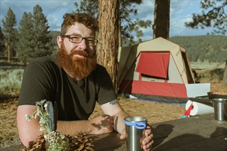Caucasian man drinking at campsite