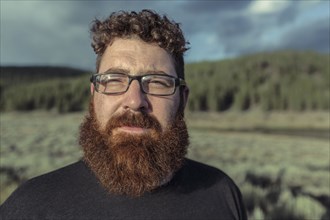 Caucasian man with beard standing in remote field