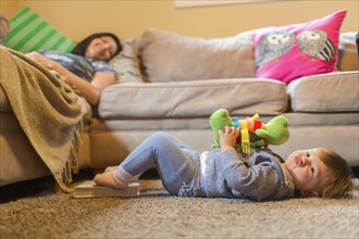 Mother and baby daughter relaxing in living room