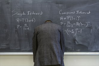 Caucasian teacher frustrated at chalkboard
