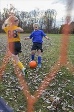 Caucasian girls playing soccer in field