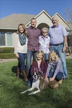Caucasian multi-generation family smiling in yard